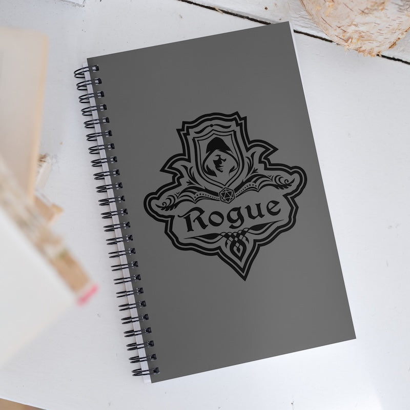 Gray notebook with a black emblem and 'Rogue' text on a white surface