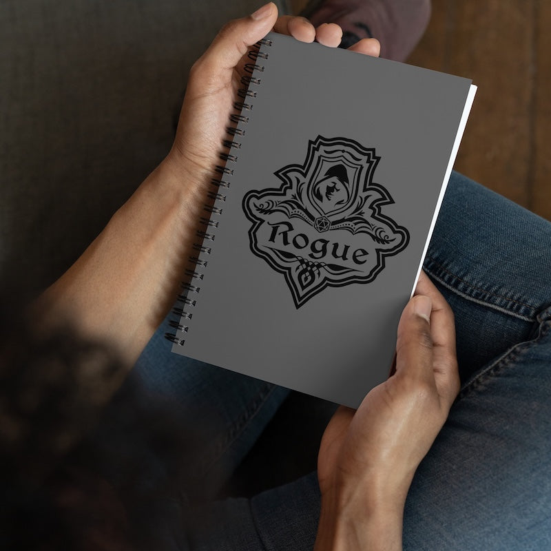 Person holding a notebook with 'Rogue' logo on the cover