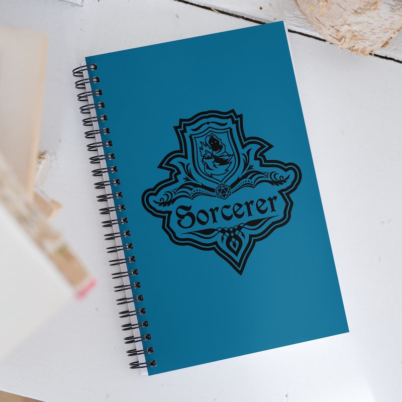 Blue notebook with 'Sorcerer' design on a white surface