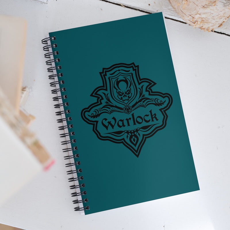 Green notebook with 'Warlock' design on a white surface
