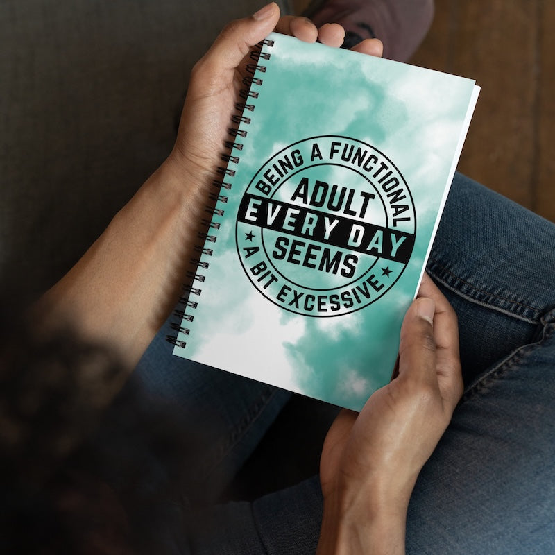 Person holding a notebook with a humorous quote on the cover