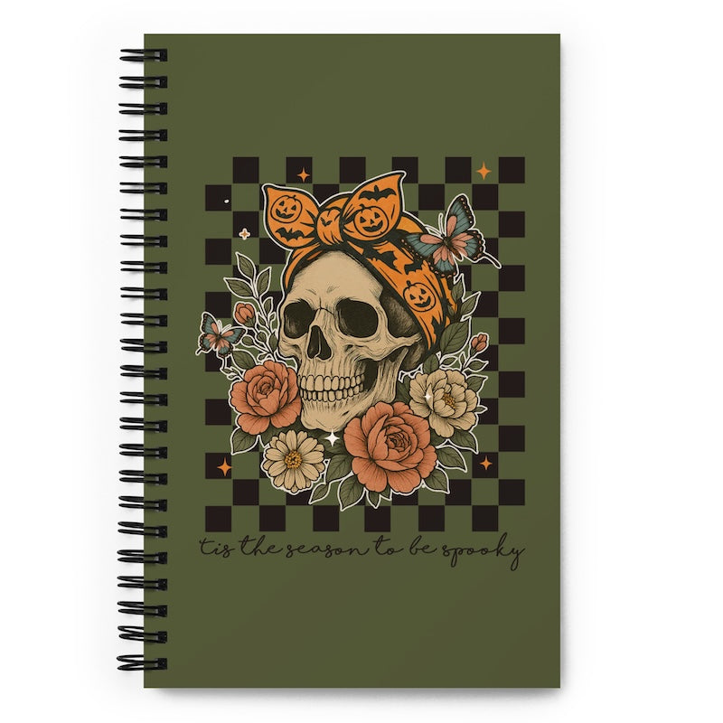 Notebook with a skull and pumpkin design on a green background