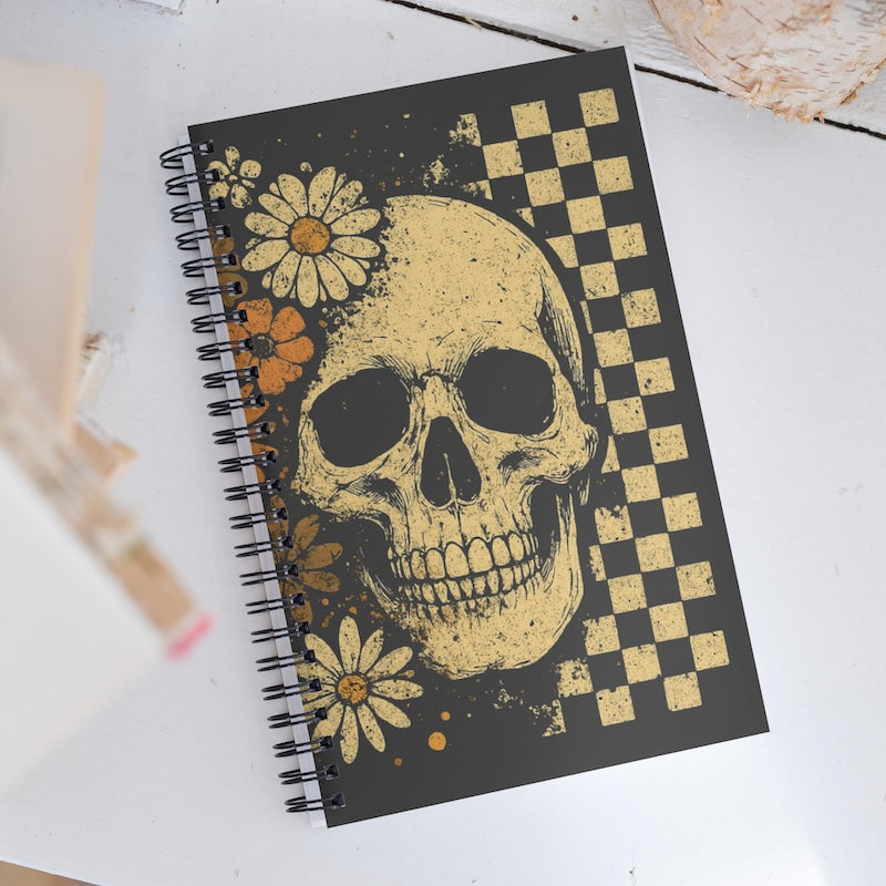Notebook with skull and floral design on a white surface