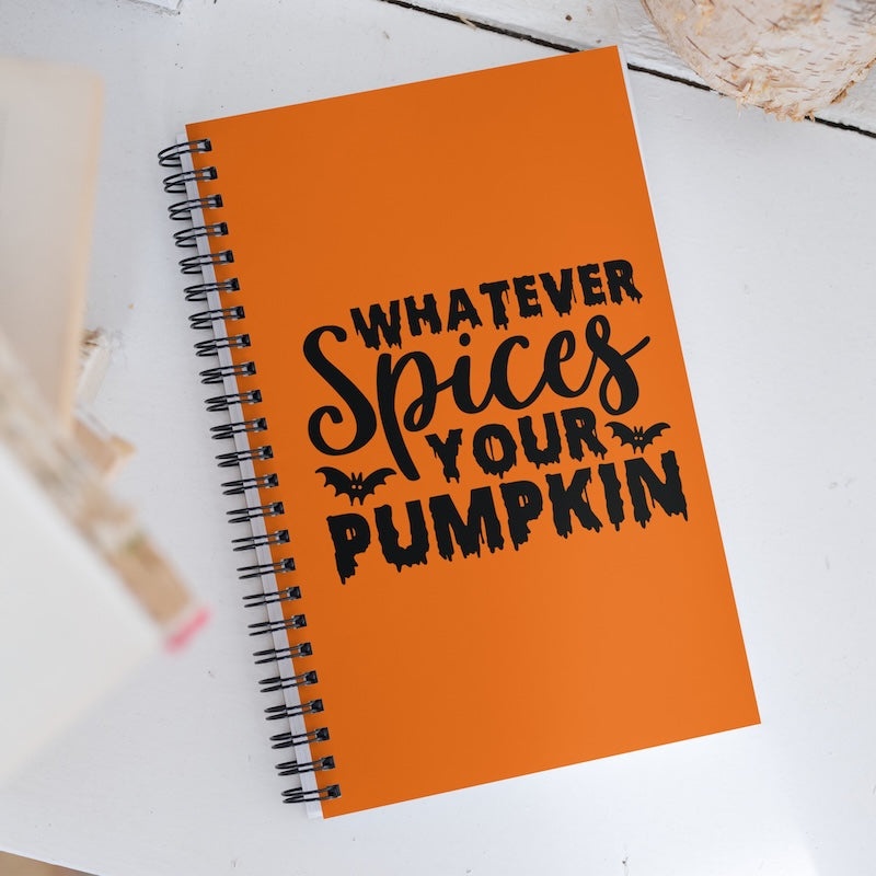 Orange notebook with Halloween-themed text on a white surface