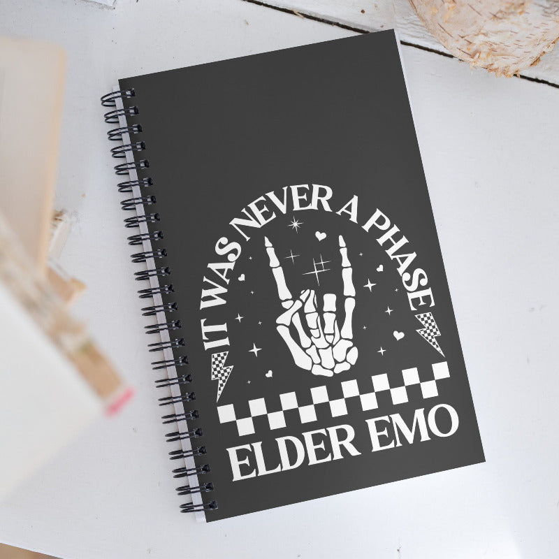 Black notebook with white text and design on a light background