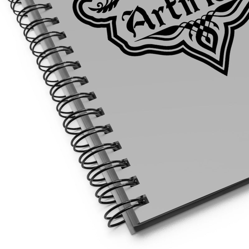 Spiral-bound notebook with a decorative logo on a white background