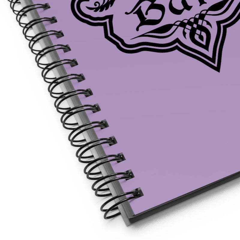 Purple notebook with black spiral binding on a white background