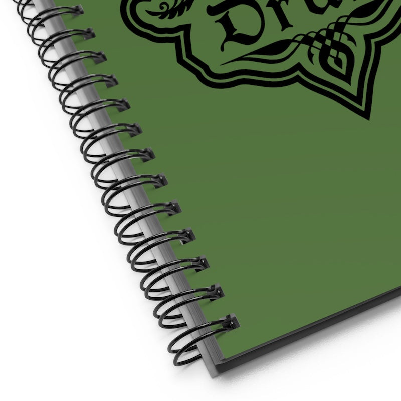Green notebook with spiral binding and decorative text on a white background