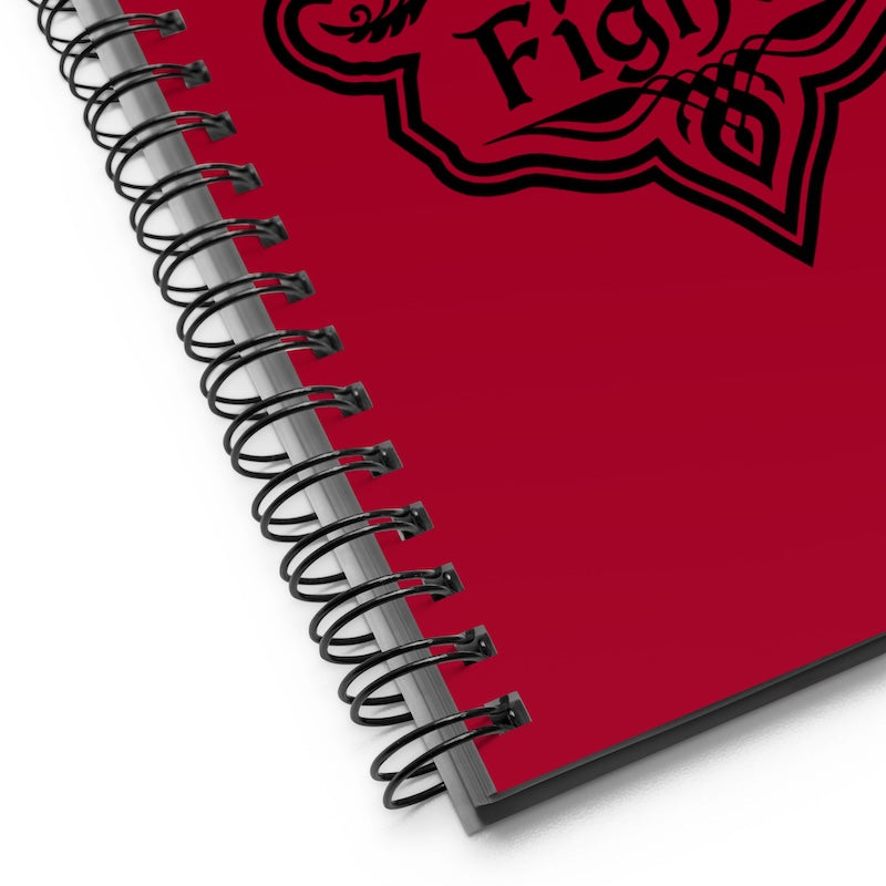 Red notebook with a black spiral binding and a red and black emblem on a white background