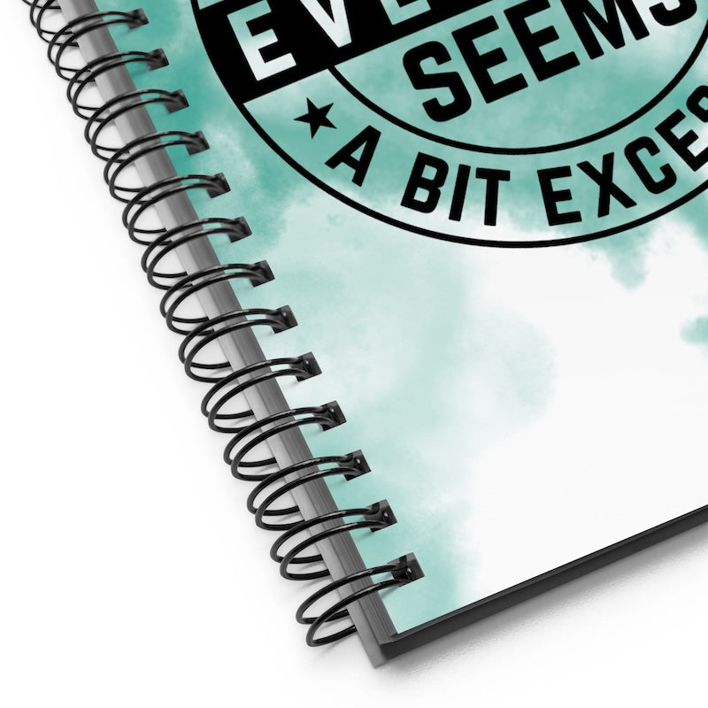 Spiral-bound notebook with a motivational quote on a light blue watercolor background