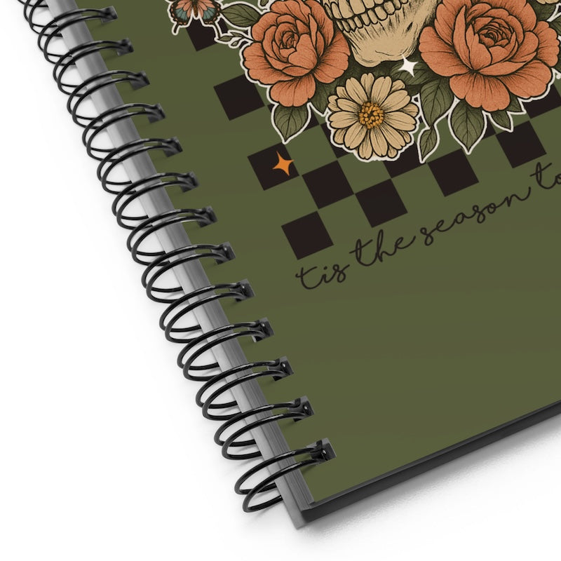 Spiral-bound notebook with floral design and text on a white background