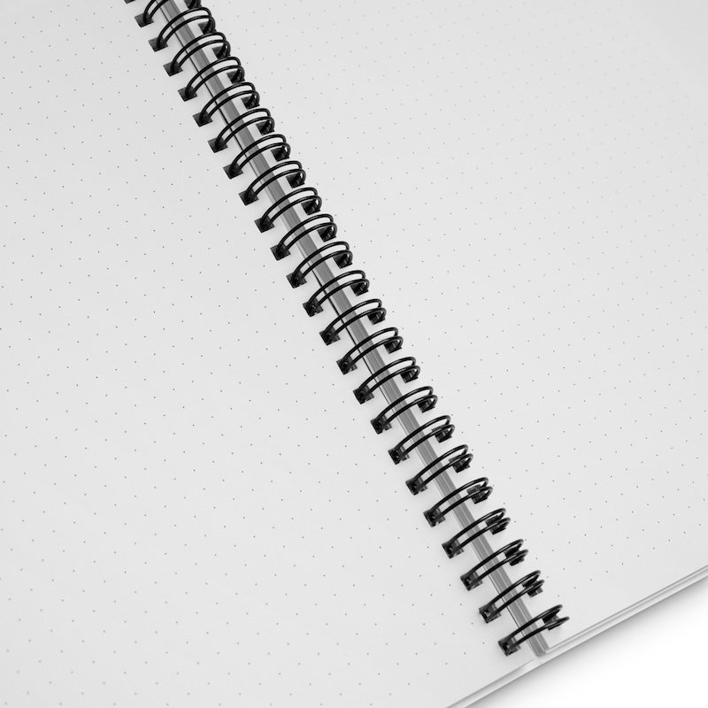 Spiral-bound notebook with white pages on a light gray background