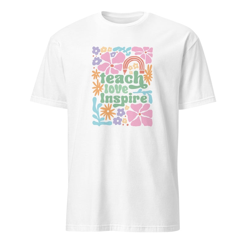 White t-shirt with colorful 'teach love inspire' design on a white background