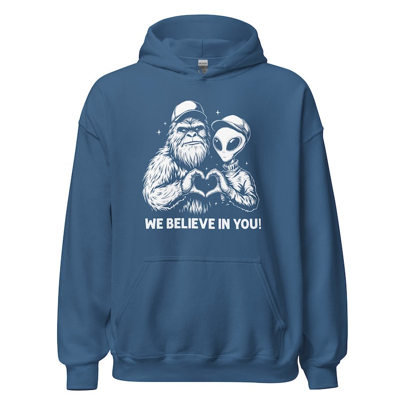 Blue hoodie with alien and creature design and 'We Believe In You!' text on a white background