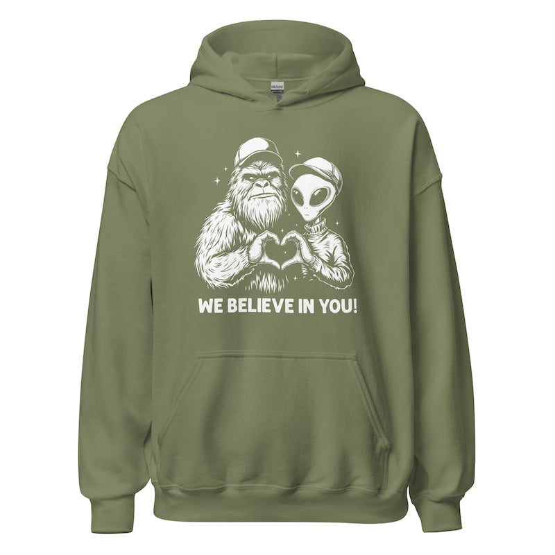 Green hoodie with alien and Bigfoot design and 'We Believe In You!' text on a white background