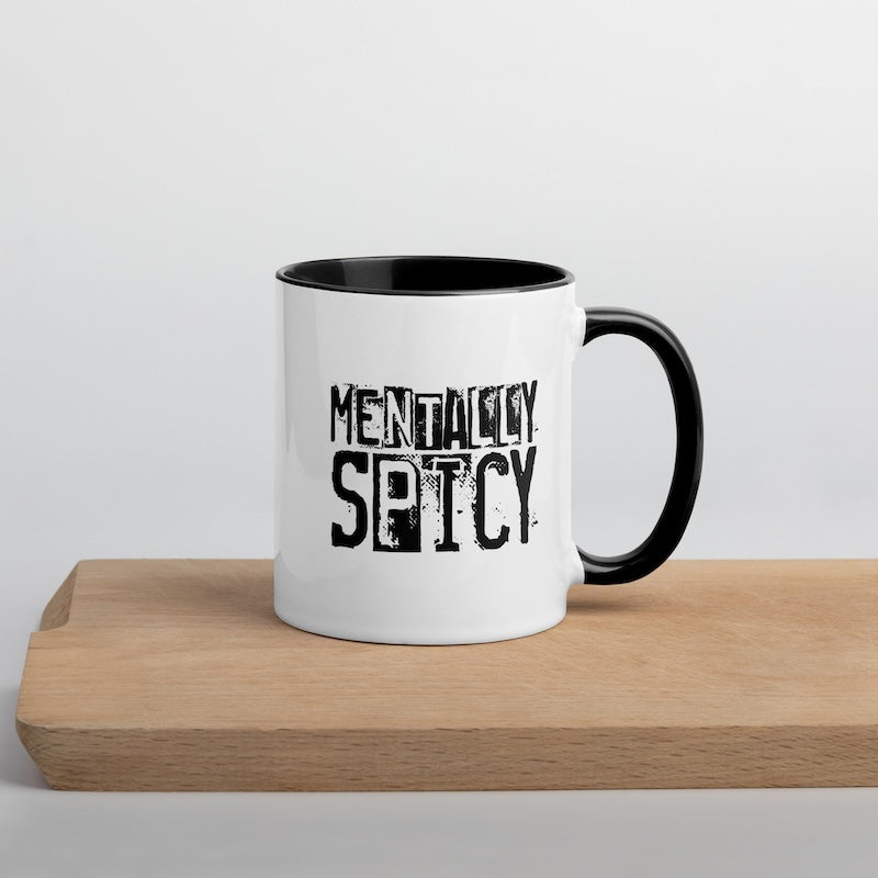White mug with black interior and handle, featuring 'MENTALLY SPICY' text on a light gray background.