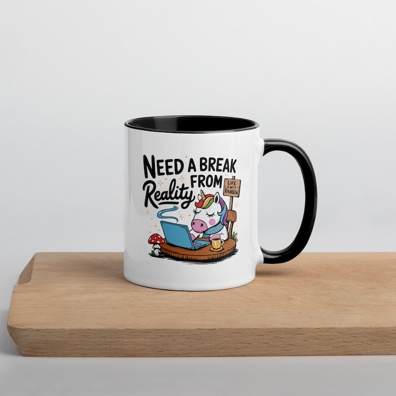 Mug with cartoon unicorn and text 'Need a Break from Reality' on a wooden surface.
