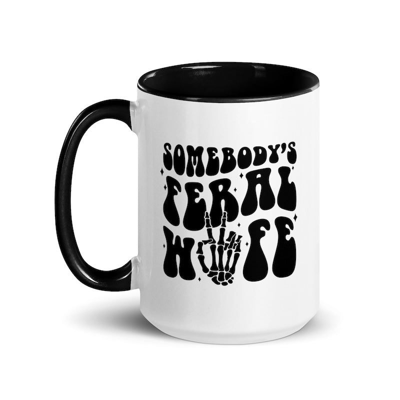 White mug with black interior and handle, featuring text and skeleton hand design.