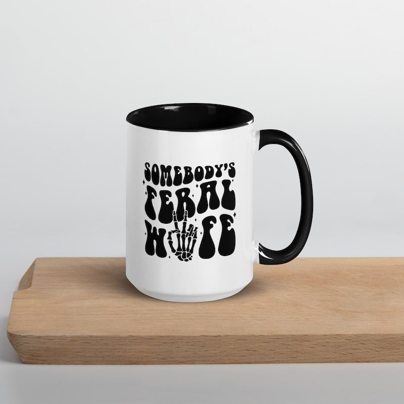White mug with black interior and handle, featuring text and graphic design on a light gray background.