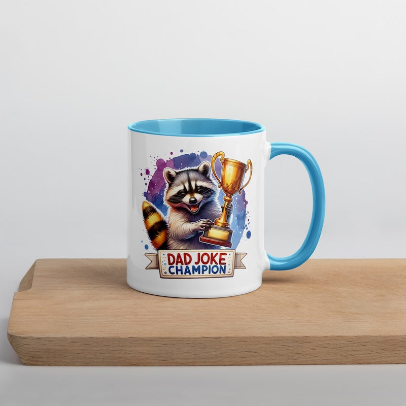 Mug with raccoon holding a trophy and 'Dad Joke Champion' text on a wooden surface.