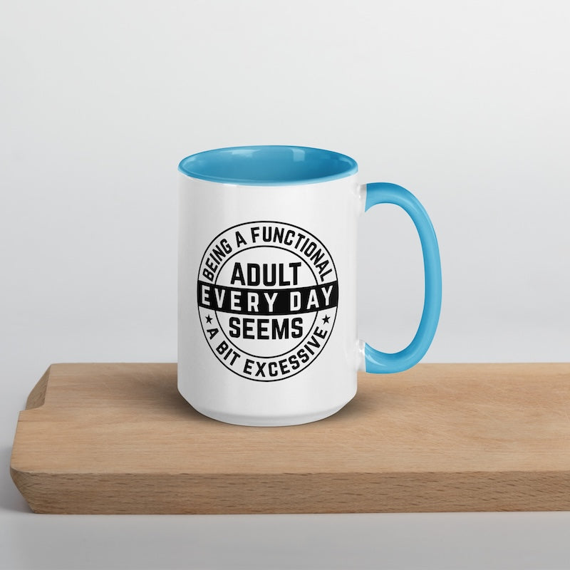 White mug with blue interior and handle on a wooden surface, featuring a humorous quote.