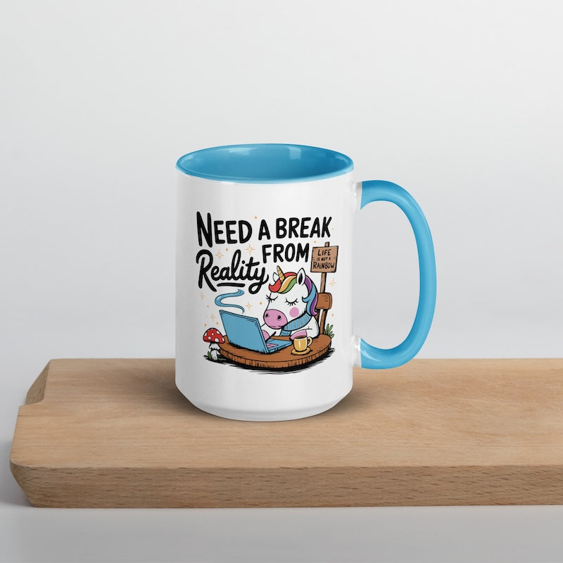 Mug with cartoon unicorn and text 'Need a Break from Reality' on a wooden surface.