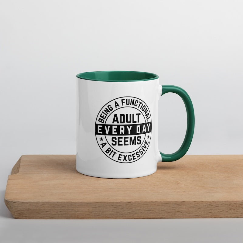 White mug with green interior and handle, featuring a humorous quote on a wooden surface.