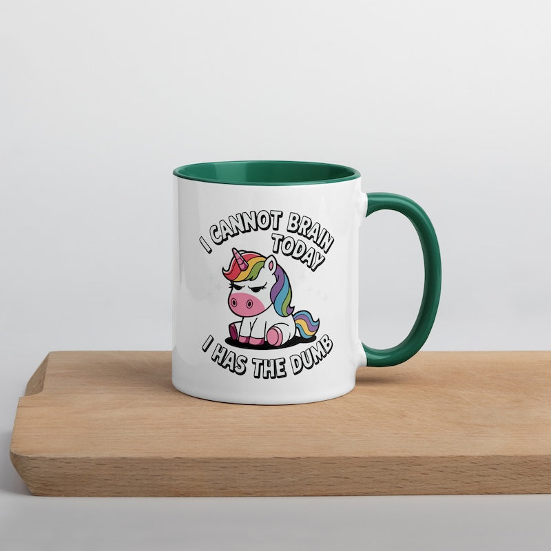 Mug with a unicorn graphic and humorous text on a wooden surface.