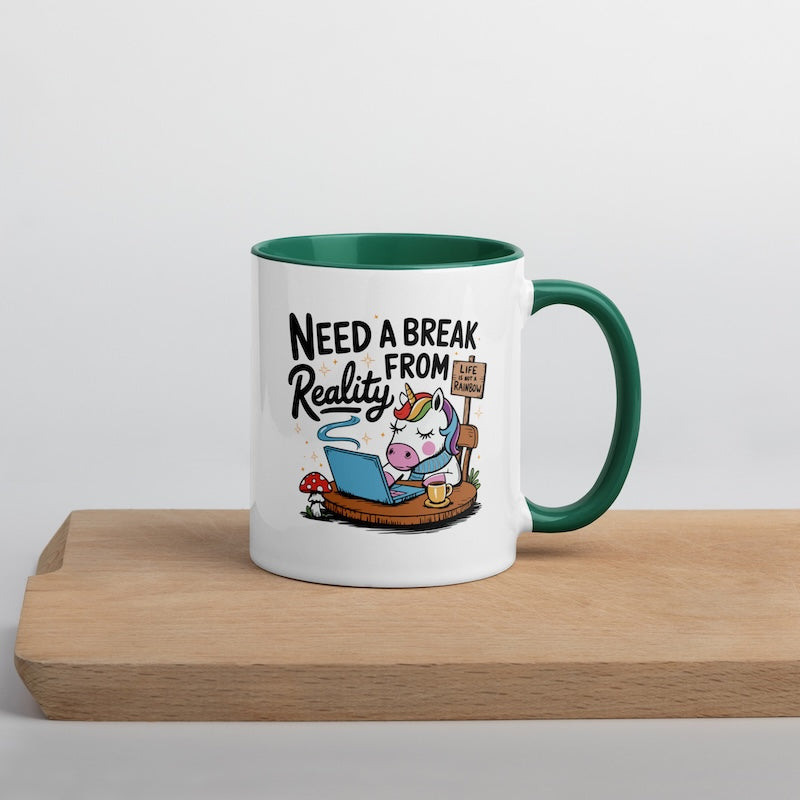 Mug with cartoon unicorn and text 'Need a Break from Reality' on a wooden surface.