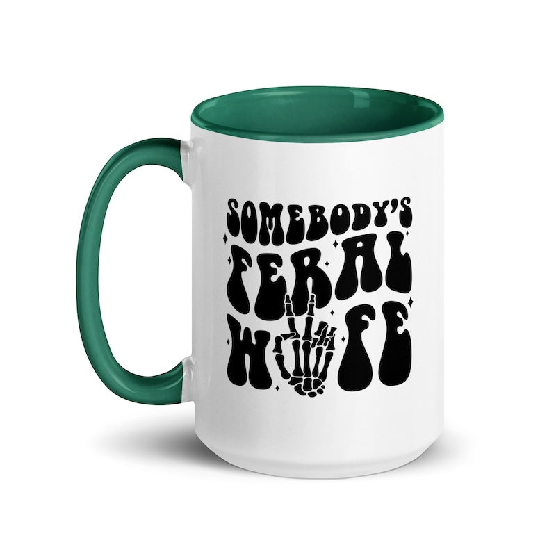 White mug with green interior and handle, featuring black text and skeleton hand design.
