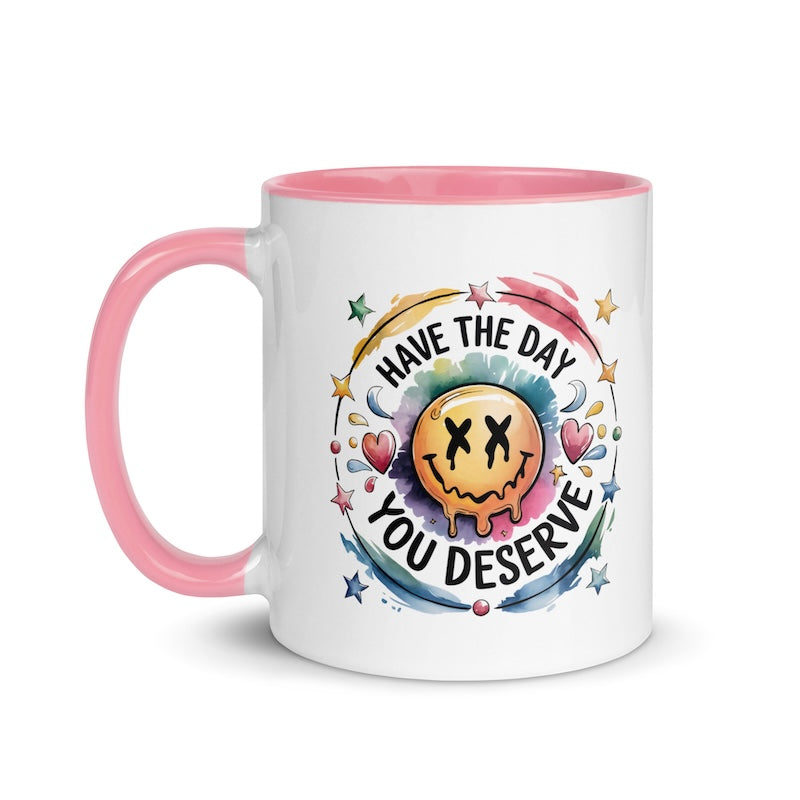 Mug with pink handle and colorful design on a white background