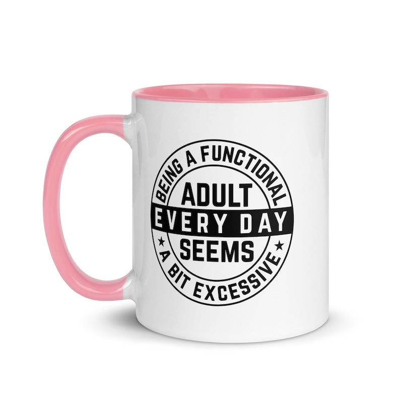 White mug with pink handle and interior, featuring a black circular design with text.