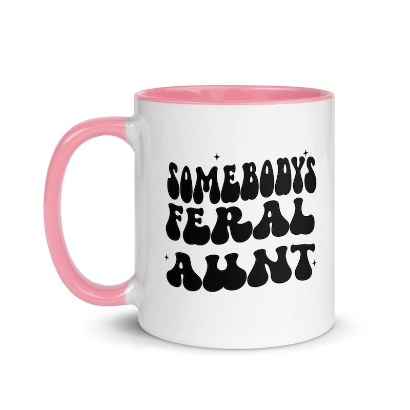 White mug with pink handle and interior, featuring black text on a white background