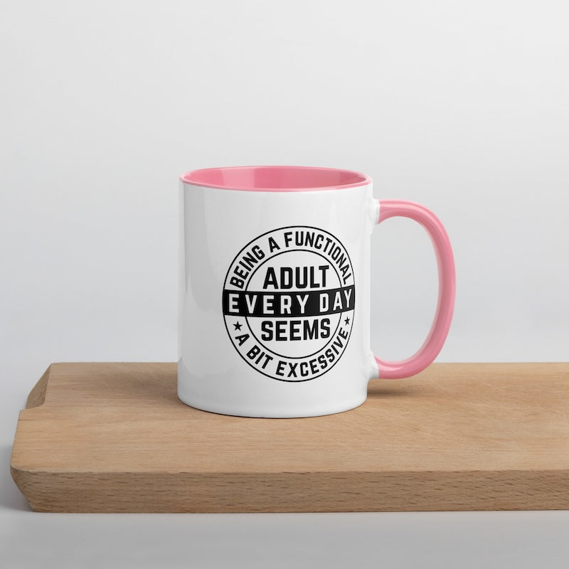 White mug with pink interior and handle, featuring a black text design on a light gray background.