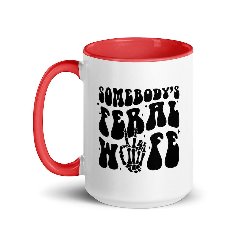 White mug with red interior and handle, featuring black text and skeleton hand design.