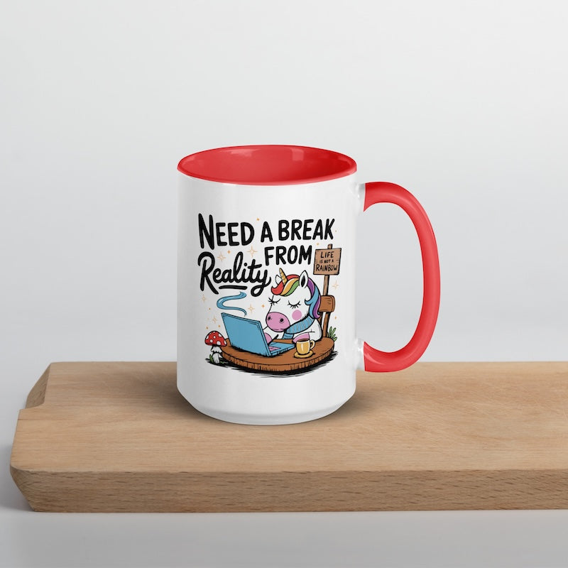 Mug with cartoon unicorn and text 'Need a Break from Reality' on a wooden surface.