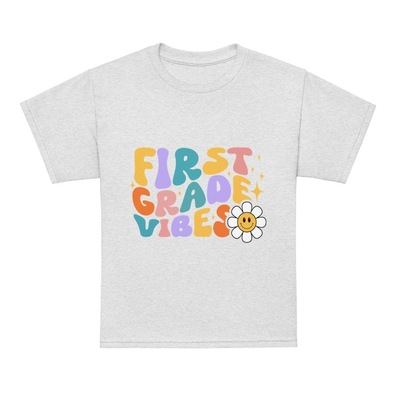 Gray t-shirt with 'First Grade Vibes' text and a flower graphic on a white background