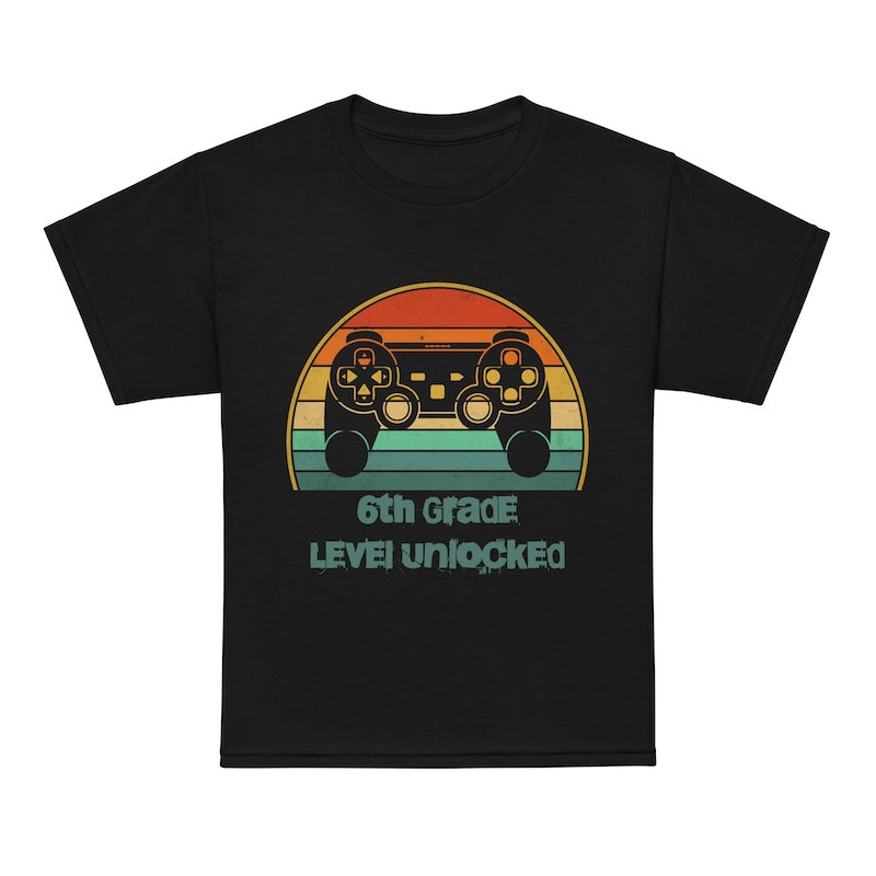 Black t-shirt with a colorful graphic of a game controller and text '6th Grade Level Unlocked' on a white background.
