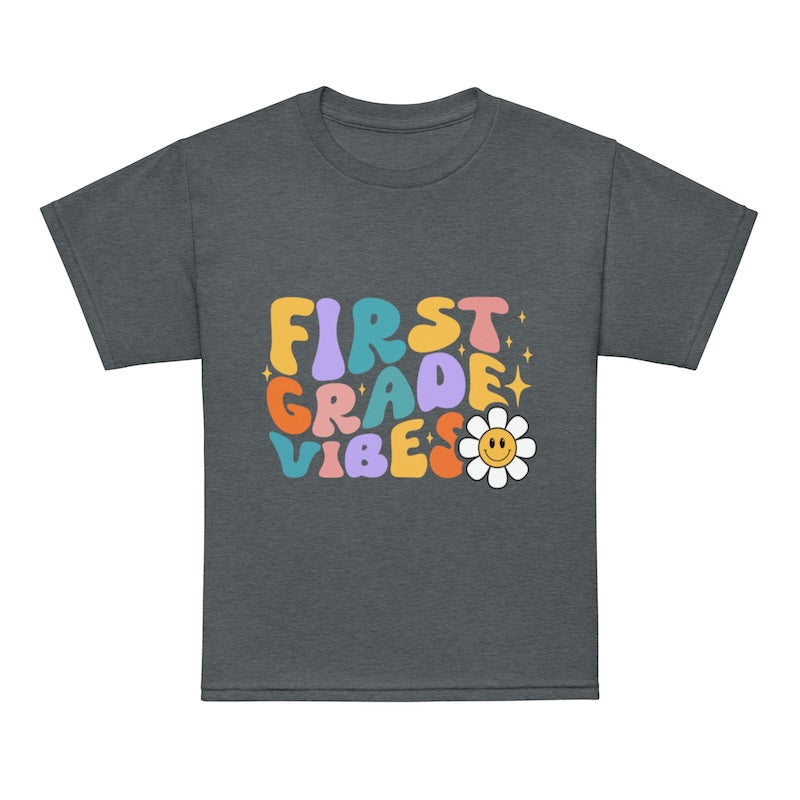Gray t-shirt with colorful 'First Grade Vibes' text and a flower graphic on a white background